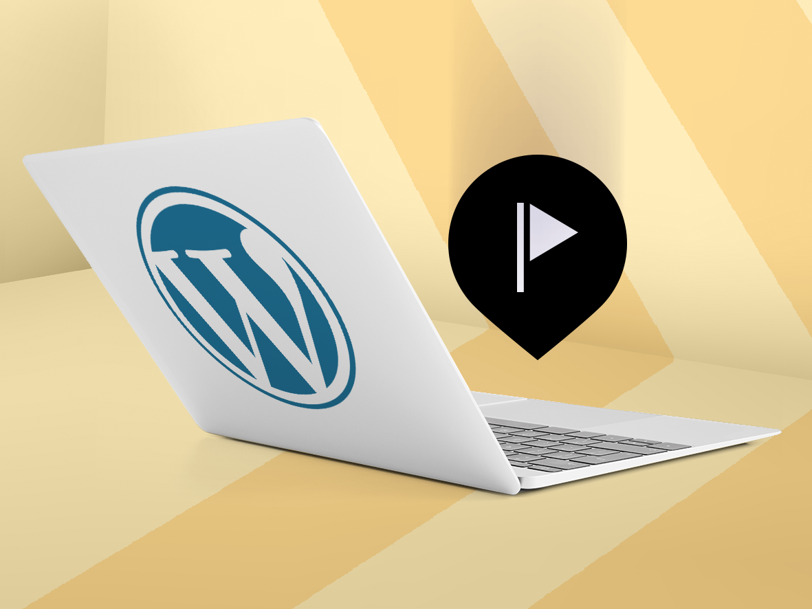 Wordpress logo and location pin on top of a laptop. 